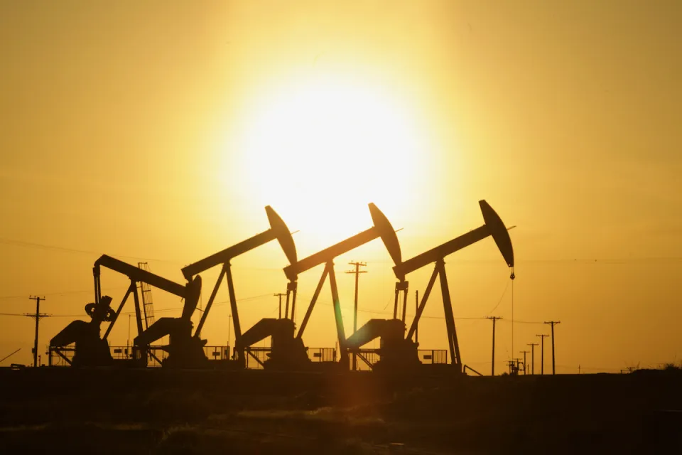 Four oil wells sillhouetted against the sunset.